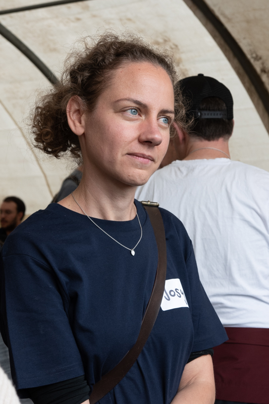 Frau mit blauem T-Shirt, die in die Ferne blickt.