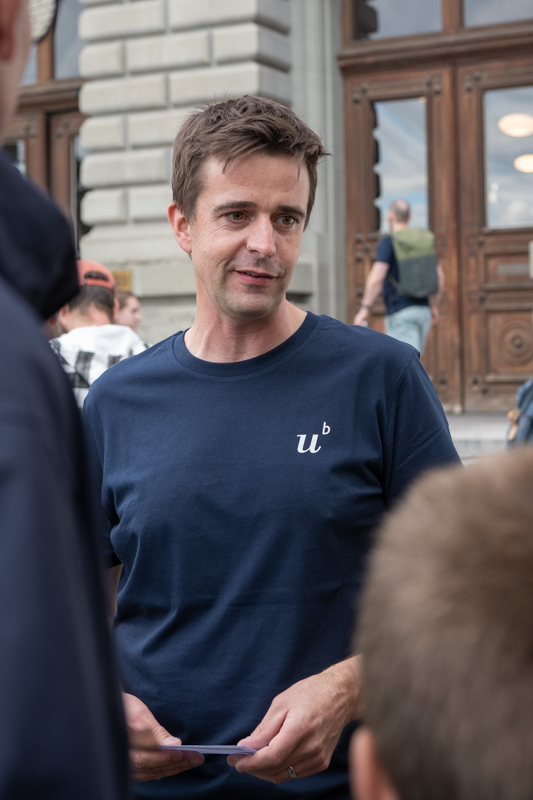 Mann mit blauem T-Shirt, der etwas erklärt.